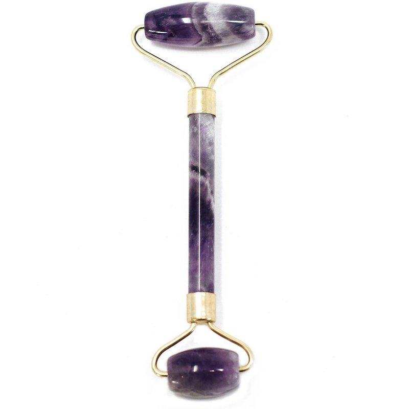 Gemstone face roller in amethyst, dual-ended for skincare, reduces puffiness.