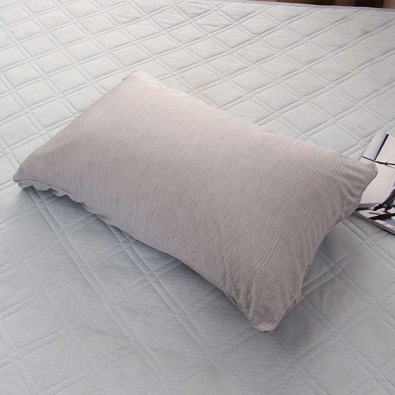 Light grey cooling blanket and pillowcase on a bed, ideal for summer comfort.