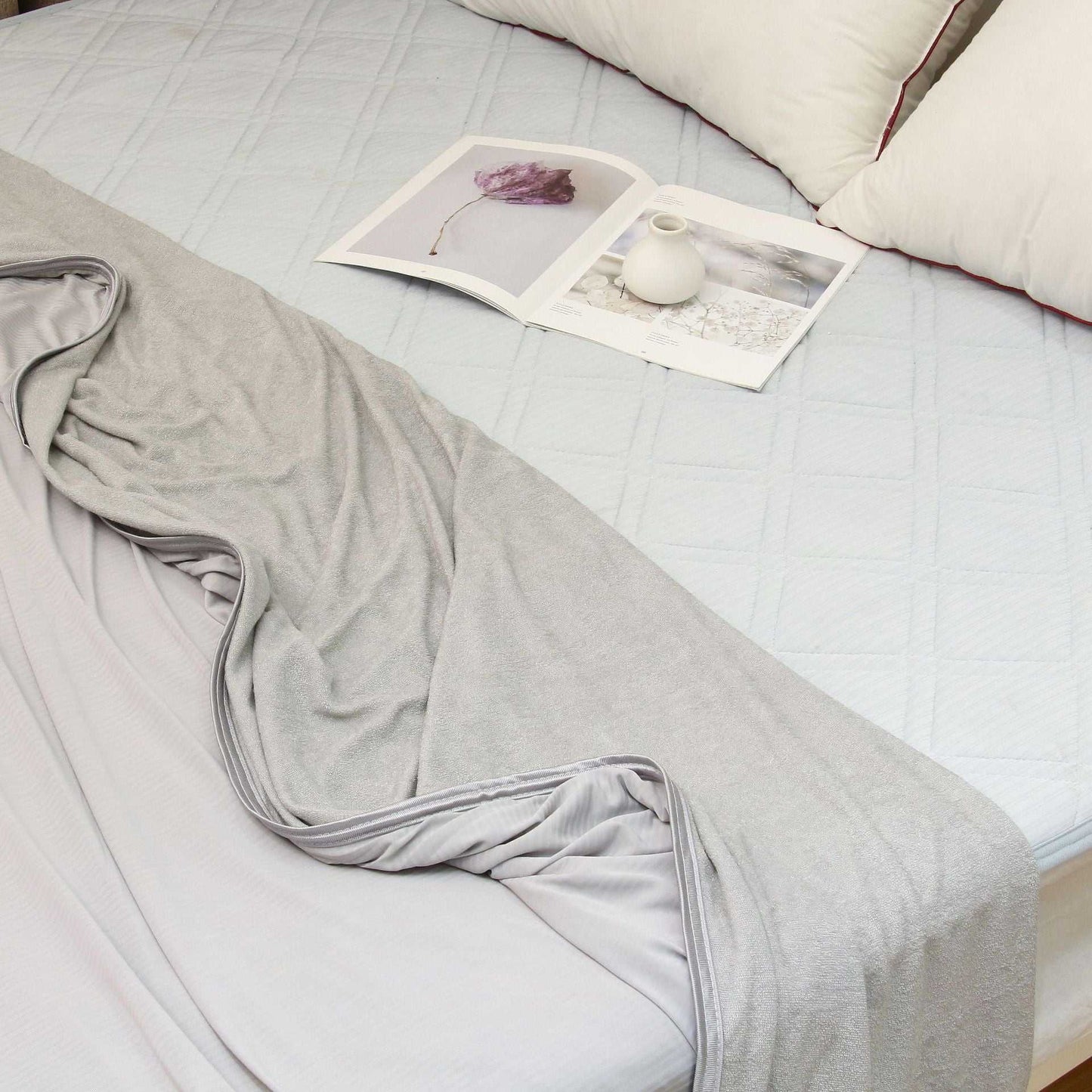 Lightweight grey summer cooling blanket on a bed, designed with advanced Japanese Q-Max 0.4 cooling fibers for heat reduction.