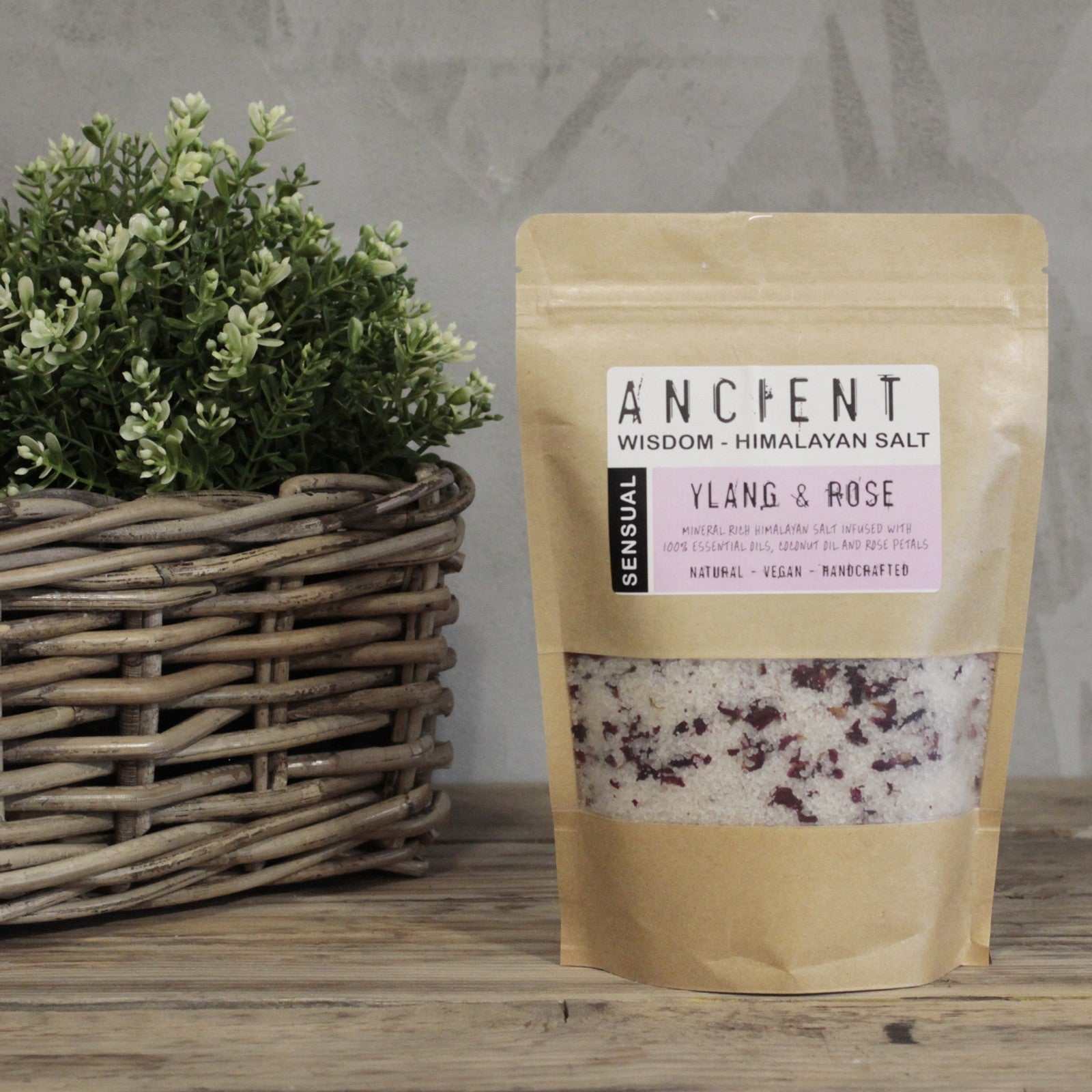 Himalayan bath salt blend in kraft packaging with plant background.