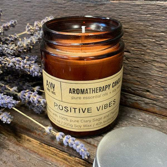 Aromatherapy candle in amber glass jar with lavender, promotes optimism and joy.