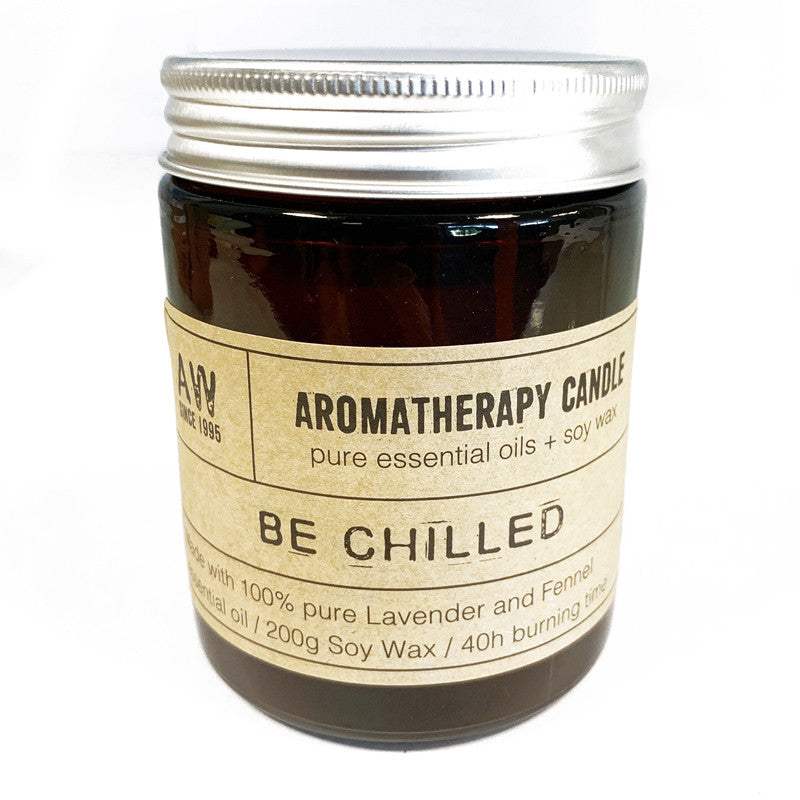 Aromatherapy candle in amber glass jar labeled "Be Chilled," featuring pure essential oils and natural soy wax.