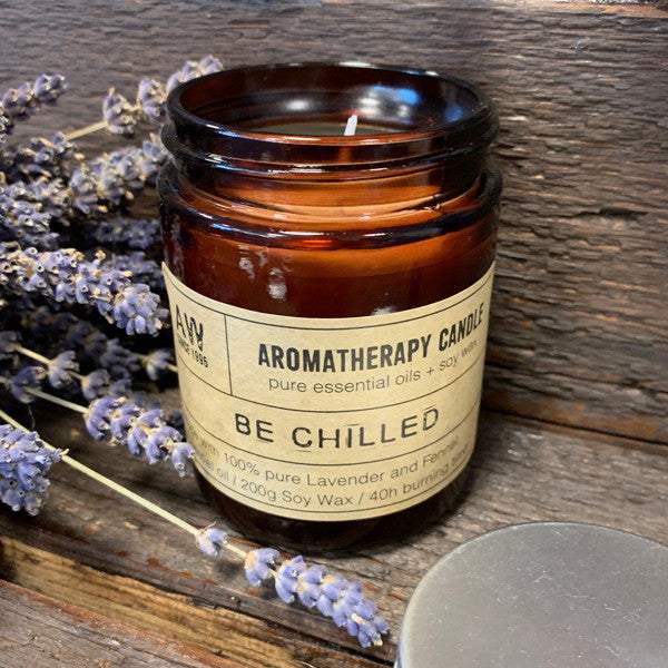 Aromatherapy candle in amber glass jar with lavender, promoting relaxation and tranquility.