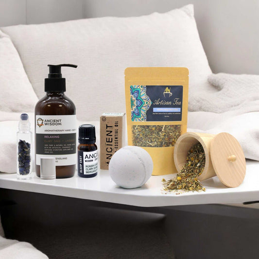 Sweet Dreams Kit with bath bomb, lotion, essential oil, tea, and roller bottle on white table.