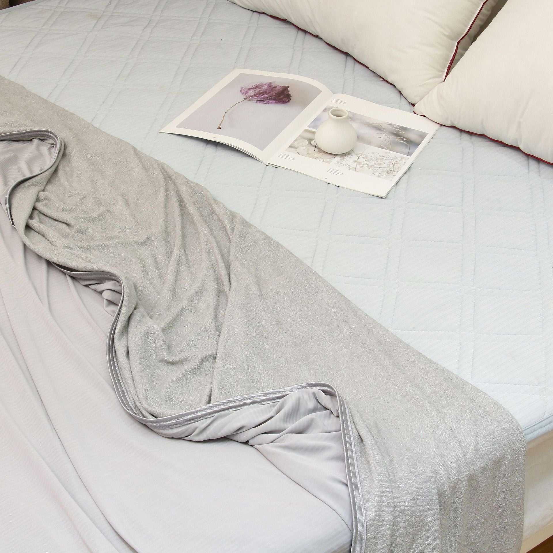 Lightweight grey summer cooling blanket on a bed, designed with advanced Japanese Q-Max 0.4 cooling fibers for heat reduction.