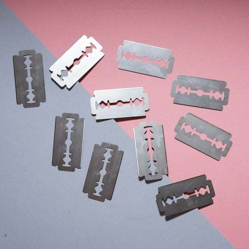FLON Safety Razor Blades, stainless steel, double edge, floating against a pink background.