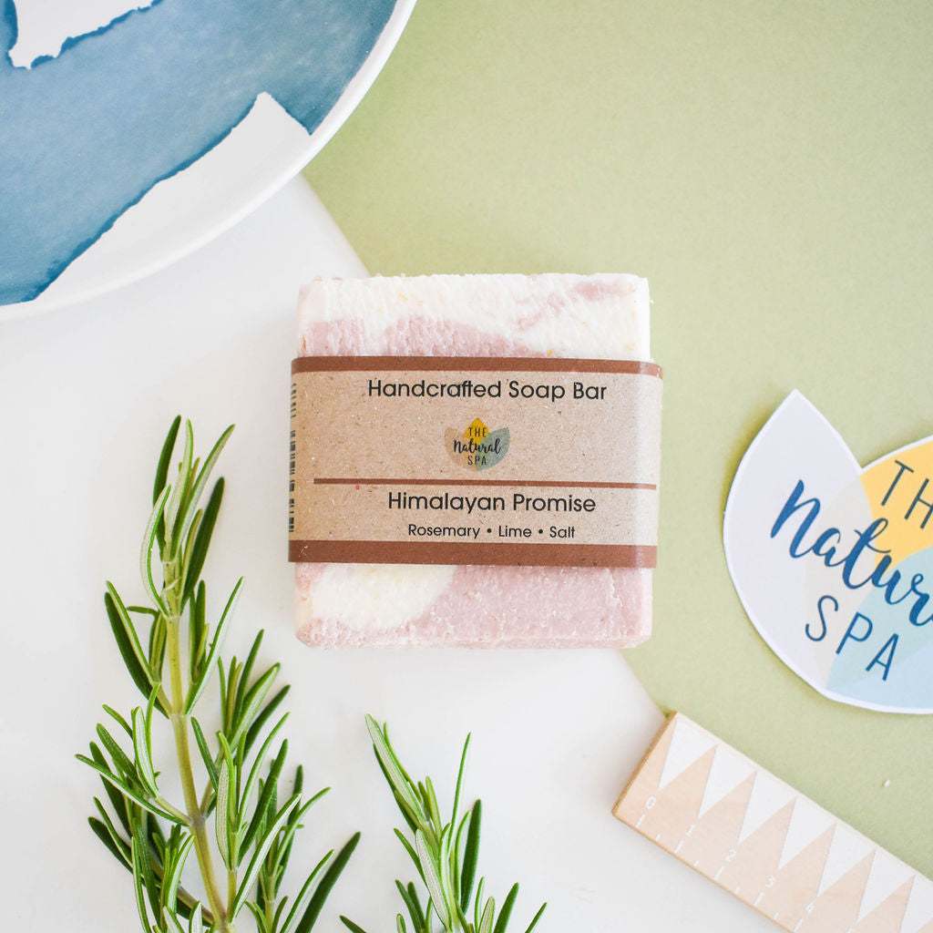 Handcrafted Natural Spa Himalayan Promise Soap Bar with lime and rosemary essence, featuring gentle exfoliation properties, displayed with rosemary sprigs.