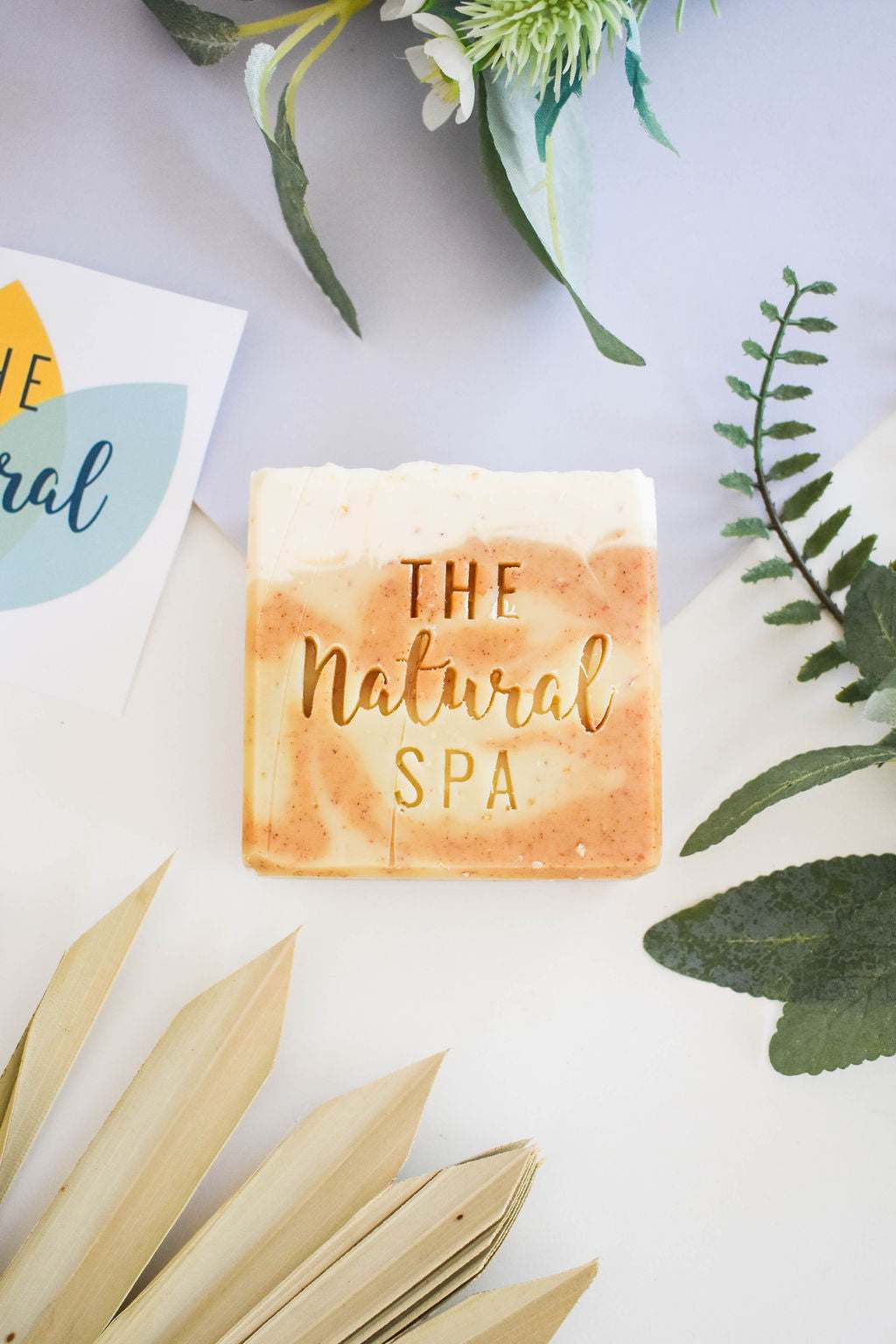 Natural Spa Eves Garden Soap Bar with lavender, lemongrass, and pine scent, displayed with greenery.