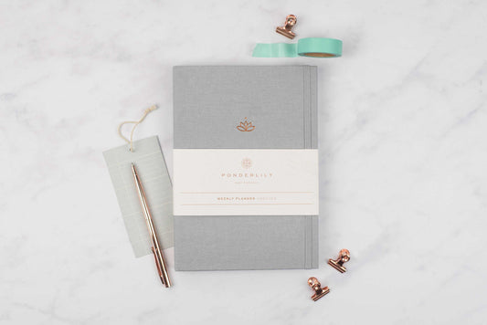 Grey Undated Weekly Ponderlily Planner with A6 dot grid, eco-friendly materials on marble background.