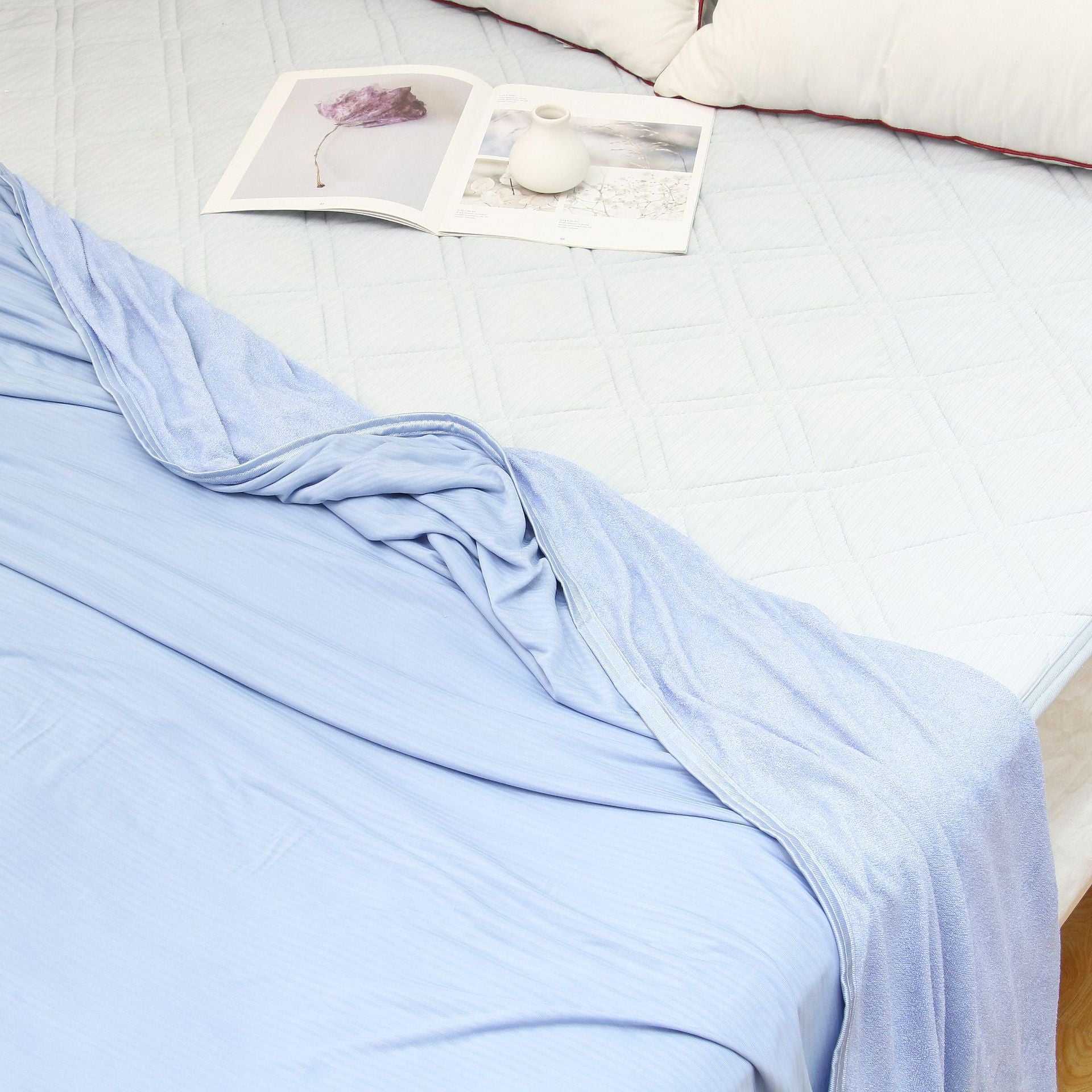Lightweight summer cooling blanket with advanced Japanese Q-Max fibers on a bed.